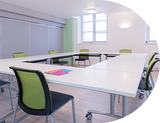Tables blanches et chaises vertes de la salle à Remiremont